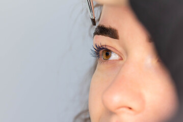 Young Caucasian Woman on the brow beauty procedures. Professional care for face. Brows coloring,...