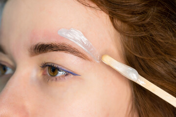 Brow master applying hot wax for brows epilation, lamination and waxing. Professional care for face...