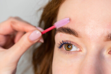 Young Caucasian Woman on the brow beauty procedures. Professional care for face. Brows coloring, wax and lamination. 