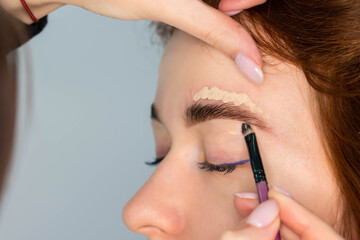 Young Caucasian Woman on the brow beauty procedures. Professional care for face. Brows coloring,...