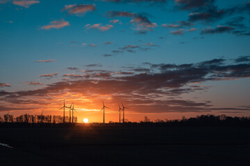 Fototapeta premium Sonnenaufgang mit Windrädern