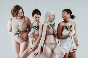 Group of multiethnic women with different kind of skin posing together in studio. Concept about...