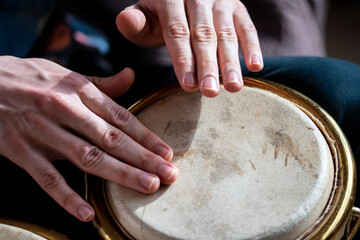closeup male hands playing bongo
