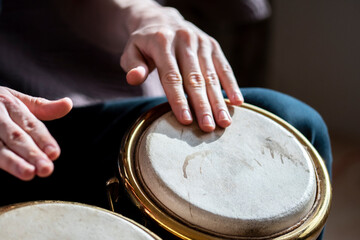 closeup male hands playing bongo