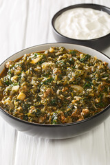 Turkish Kiymali Ispanak stew Spinach with ground meat, onions and rice closeup in the bowl on the table. Vertical