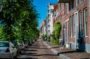 Fototapeta na wymiar Rotterdam, Netherlands - July 5, 2019: Unidentified Dutch woman walking in the streets of Delfshaven in Rotterdam, Netherlands