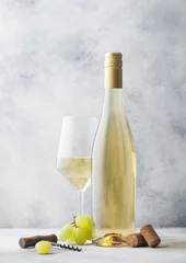 Gordijnen Glass and bottle of summer white wine with grapes, corks and corkscrew on light background. © DenisMArt