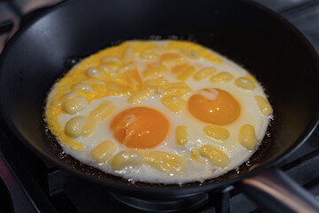 Fried eggs in a pan with butter for breakfast or lunch simple cooking.