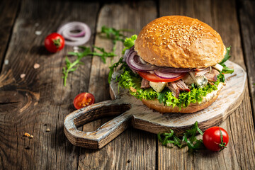 Fresh burger with blue cheese and arugula on wooden background. fast food and junk food concept