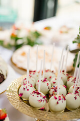 White cake pops on a golden plate, Wedding candy bar