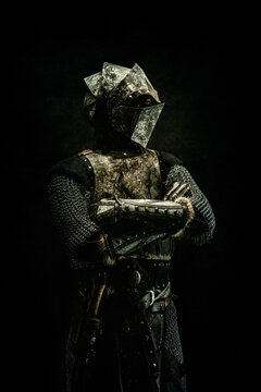 Portrait of a medieval fighter in armor with his arms crossed