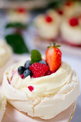 Close up of a Mini Pavlova dessert decorated with blueberry and strawberries on a candy bar, wedding buffet table