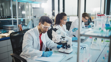 Fototapeta na wymiar Medical Science Laboratory: Row of Diverse Team of Multi-Ethnic Young Scientists Looking Under Microscope, Analyze Chemicals, Talk, Solving Problems. Biotechnology Specialists working in Advanced Lab