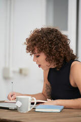 Fototapeta premium young digital nomad curly-haired girl working happily with her computer and her smartphone from a Spanish terrace on a warm sunny day