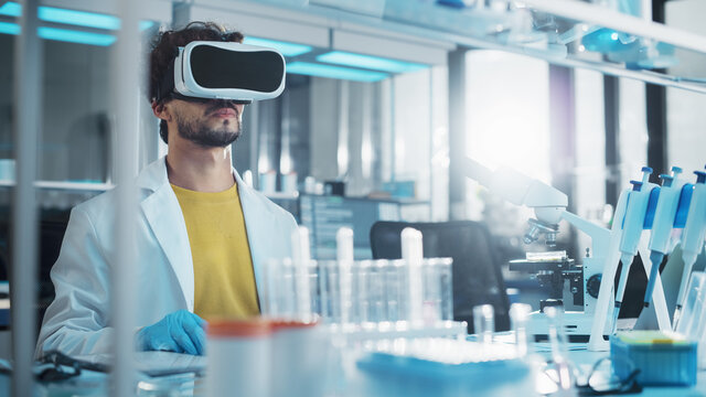 Futuristic Medical Research Laboratory: Research Scientist Wearing Virtual Reality Headset, Does Augmented Reality Research Using Smart Gestures. Big Data AI Biotechnology Research in Progress