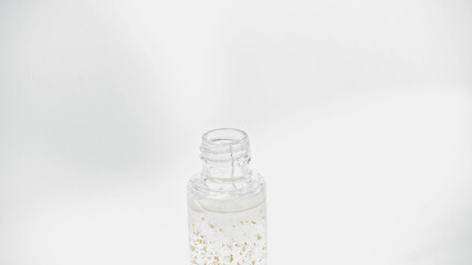 close up of glass bottle with essential oil on white