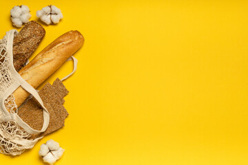 Bread in cotton eco-friendly bag on yellow background