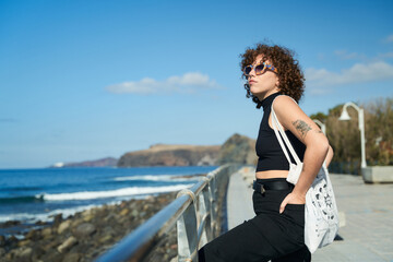 young girl with curly hair enjoying the landscape on a sunny day in the canary islands
