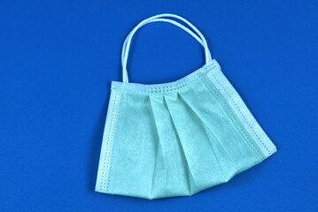 Face mask in the form of a bag with handles on a blue background. The concept of using personal...