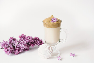 Dalgon's trending drink is coffee. Coffee mug, lilac and marshmallow on a white background