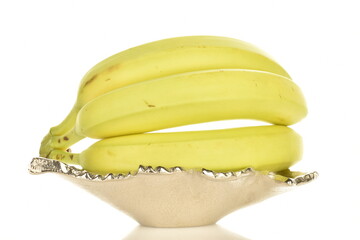 Ripe natural bunch of bananas on a metal decorative plate, close-up, isolated on white.