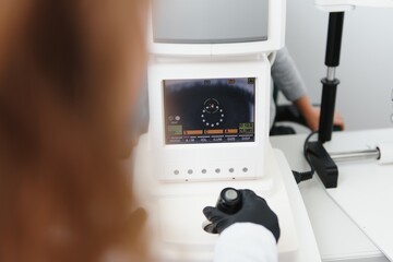 Modern medical equipment. Close up of ophthalmologist using auto refractometer while examining child eyes