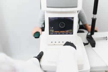 Fototapeta premium Modern medical equipment. Close up of ophthalmologist using auto refractometer while examining child eyes