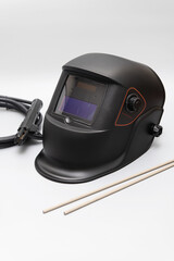 Inverter welding machine, welding equipment, on a gray background, welding mask, welding electrodes, high-voltage wires with clamps, a set of accessories for arc welding.