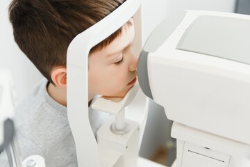 Vision correction in a boy. Close-up face of patient boy. Super modern equipment in a modern clinic for eye examination