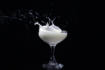 Splash drink into the glass with black background