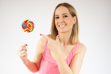 Smiling pretty young woman holding a lollipop isolated over white background