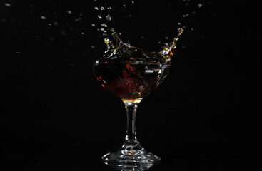 Splash drink into the glass with black background