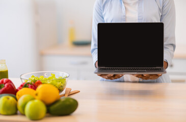 Unrecognizable Woman Showing Laptop Empty Screen Standing In Modern Kitchen