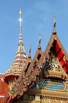 Wat Chaitharam or Chalong Temple. The most famous and important temple in the province. An image of a pagoda roof with a sun glare at the peak against a blue sky background.