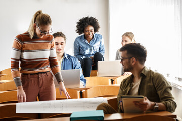 Group of students in classroom.	Preparing for lecture.