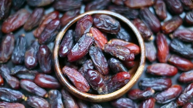 organic fresh dates. Inside the wooden plate and blurred background