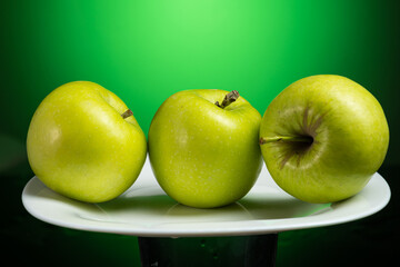 a whole green apple on a white plate