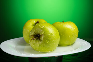 a whole green apple on a white plate