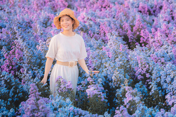 Portrait of young attractive beautiful happy asian woman with white dress and brown straw hat stand...
