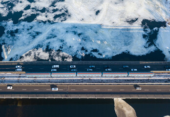 Aerial drone view. The Kiev metro train pass across the bridge through the Dnieper river. Winter sunny morning.