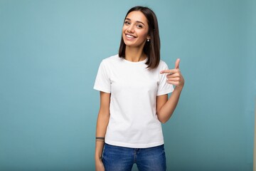 Portrait of young beautiful happy smiling brunette woman wearing trendy white t-shirt with empty...