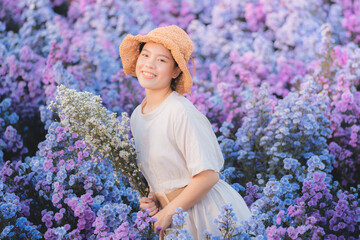 Portrait of young attractive beautiful happy asian woman with white dress and brown straw hat stand...