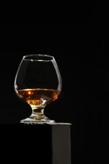 Cognac glass, isolated on a black high background. Cognac.