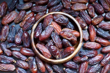 organic fresh dates. Inside the wooden plate and blurred background
