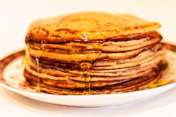 Pancakes with honey on a white background