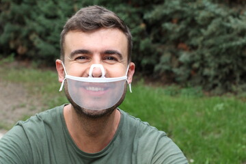 Man smiling with transparent plastic protective mask 
