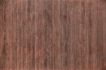 An image of a texture from deck boards. Dark mahogany, vertical planks. Without fastening elements. Wall lined with wood. Wooden background for a banner. Natural material.