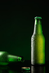 Two bottle of cold beer with water drop on dark green background with copyspace. Vertical format.