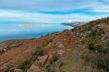 Fototapeta na wymiar Agriculture field terraces on Isla del Sol (Sun Island) with the sunlit Moon Island, Titicaca Lake, Bolivia
