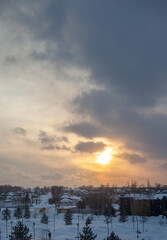 The sun among the clouds over the winter city. Beautiful background